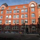 Großer mehrstöckiger Jugendstil-Altbau mit Backsteinfassade, Ecke Bergheimer und Mittermaier-Straße mit s Gebäude