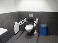 in Ecke Hänge-/Wand-WC, beidseitig Stützen, rechts WC-Papierrolle und Heizung, links Klingel und Hygieneeimer