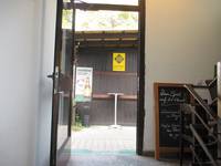 offene einflügelige Glastür die ins freie führt, rechts von der Tür ein Schild des dazugehörigen Restaurant