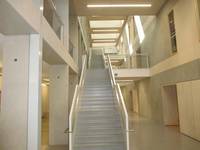 geradeläufige Treppe über mehrere Etagen mit Podesten, Handlauf links und rechts, ab 1. Stock brückenähnliche Zugänge zu den Türen