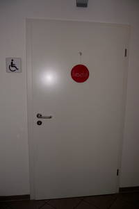 links neben Tür Schild mit Rollstuhl-Symbol, auf Tür Schild zum Umdrehen