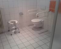 Toilette mit Haltegriffen und Duschsitz