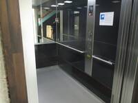 Ein offener Aufzug mit Tastatur, Handlauf und Spiegel
