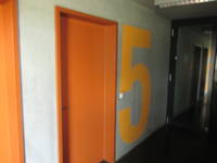  Tür in einer hellen Wand, links neben der Tür ist über gesamte Türhöhe Ziffer 5 angemalt