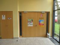 breite, zweiflüglige Holztür in einer gelben Wand. Die linke Tür ist beschriftet: Albert-Fränkel-Saal
