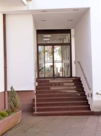 Eingang liegt im Gebäude zurückversetzt, davor führt vom Sandsteinpodestaus eine Treppe zum Eingang