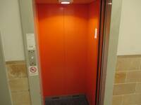 Ein offener Aufzug mit orangefarbenen Wänden
