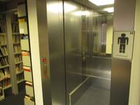 Ein offenstehender Aufzug mit Metallwänden und einem 
