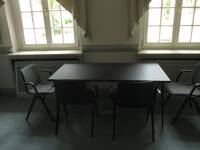 Ein kleiner Raum mit Tisch und 4 Stühlen