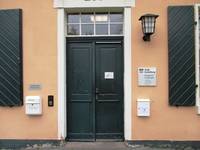 zweiflüglige Holztür mit Oberlicht. RRechts davon hängt eine Lampe, darunter ein großes Schild mit dem Logo der Stadt Heidelberg und der Aufschrift: Bürgeramt Wieblingen