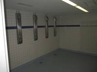 gekachelter offener Duschbereich mit 4 Duschen