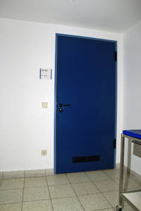 einflüglige blaue Tür, davor gefliester Boden
