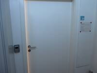 Weiße Tür in weißer Wand. Rechts neben der Tür hängt ein Schild mit dem Logo der EUTB