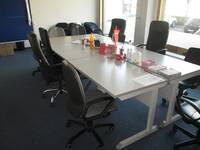 Ein Raum mit einer Tischgruppe und Schreibtischstühlen darum herum
