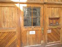 Dreigeteiltes Holzportal, in der Mitte Tür mit Rahmenfenster im oberen Bereich