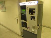 Ein Automat mit der hell leuchtenden Schrift "Kassenautomat". Weiter unten verschiedene Ein- und Ausgabemöglichkeiten.