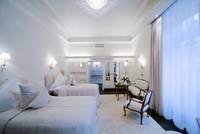 Helles Doppelzimmer mit weißen Betten, luxuriöse Ausstattung