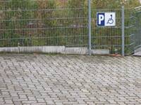 Behindertenparkplatz vor Zaun