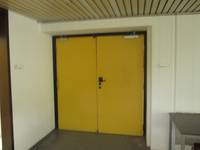 zweiflügelige gelbe Tür in einer weißen Wand