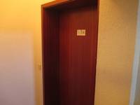 braune Holztür mit Holzrahmen Tür in einer hellen Wand