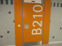 Orangefarbige Tür mit großem weißen Schriftzug B210