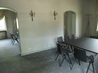  großer Raum, mittig Trennwand mit zwei offenen Bogendurchgängen. In den Räumen stehen Tische und Stühle.