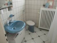 Eine Standtoilette und ein blaues Waschbecken