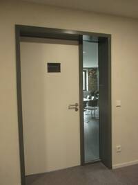 Die Tür ist weiß und hat einen grauen Rahmen.