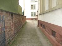 Bodenbelag aus Betonverbundsteinen, links Sandsteinmauer, rechts Gebäude Kurpfalzschule