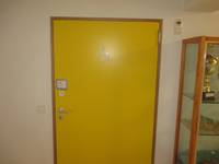 gelbe einflügelige Tür mit einem Rollstuhlfahrer Symbol darauf