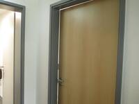 Tür in heller Holzoptik mit dunkelgrauem Rahmen in weißer Wand