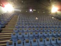 Großer Kinosaal mit mehreren nach oben treppenförmig angeordneten Sesselreihen