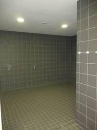 gekachelter Raum mit 2 Duschplätzen ohne Duschsitze und Haltestangen