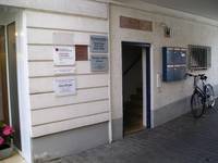 Eingangstür mit blauer Umrandung, rechts daneben blaue Briefkasten, links daneben Praxisschilder
