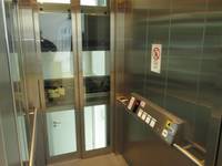 Innenraum aus Glas, rechts und links Handläude, rechts waagrecht angordnetes Bedienelement. Türen mit Metallrahmen