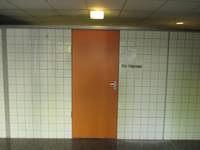 orangefarbene Tür in einer gekachelten Wand