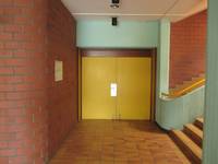 geradeaus zweiflügelige gelbliche Tür, links die Wand, rechts ein Treppenanfang