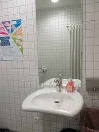 Waschbecken mit Spiegel an einer gefliesten Wand