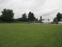 Rasenplatz mit einem Zaun und einem Tor am hinteren Ende des Feldes