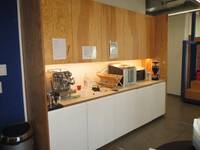 Eine Küchenzeile mit Spülbecken, Kaffeemaschine und Mikrowelle.