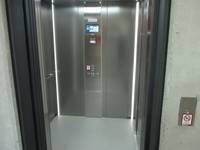 Offener stehende Aufzugtür, Blick in die Innekabine. Rechts neben der Tür ist eine Taste 