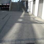 Auf einem Platz aus Betonverbundsteine mit grauen Steinen abgerenzter Parkplatz