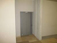 grauer, geschlossener Aufzug in einer hellen Wand 