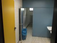 zwei hintereinanderliegenden Türen und ein gefliester Raum mit einem Teil eines Waschbecken