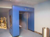 Ein etwas zurückversetzte Eingangstür in einem großen blauen Rahmen