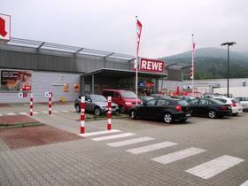 modernes Supermarktgebäude mit Aufschrift REWE