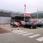 modernes Supermarktgebäude mit Aufschrift REWE