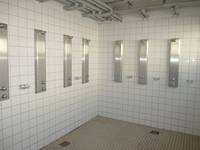 weiß gekachelter Raum mit sieben Duschplätzen