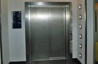 metalische Aufzugtür, rechts in der Wand integrierte Beleuchtung