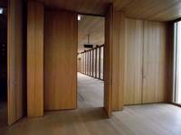 Holztür, identsich zu Wandverkleidung, offen stehend, dahinter Maguerre Saal, Rückwand verglast